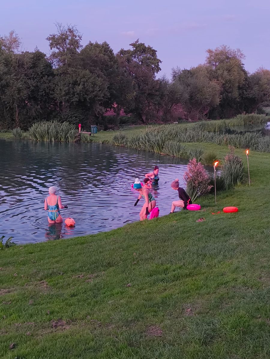people enetring the lake at sunset 