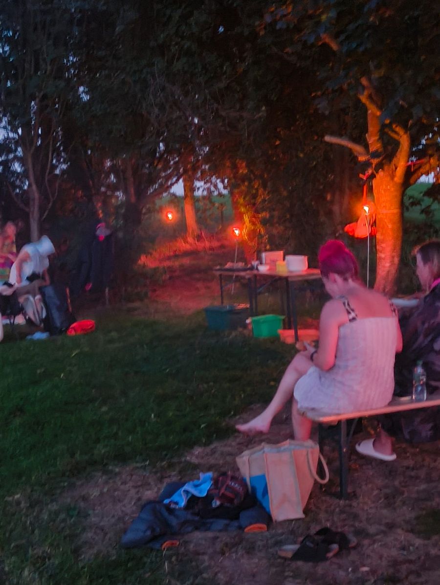 people sat around fire pit eating 