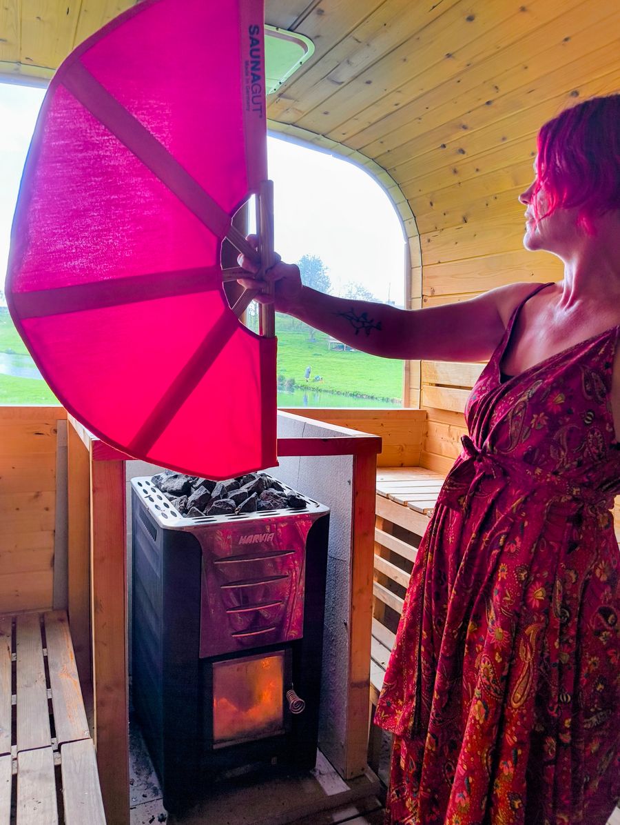 A person standing in the sauna with a sauna fan