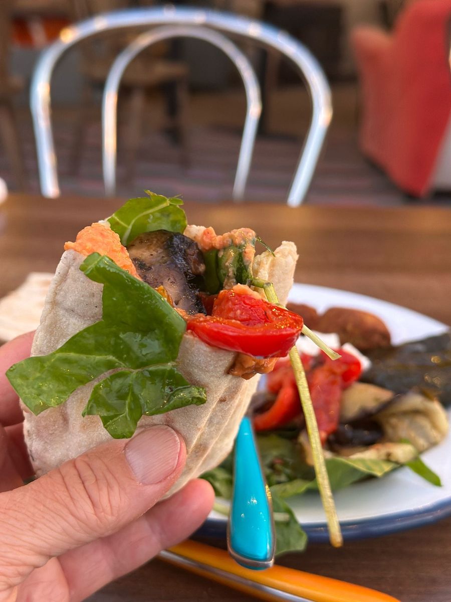 A falafel and salad wrap held up at a café table, Court Farm Lakes