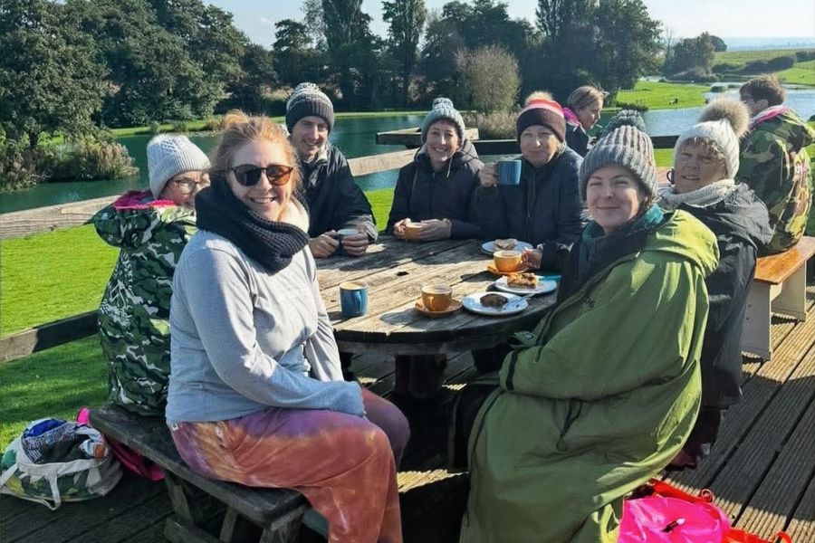 A group round the picnic table on the deck on a sunny day, Court Farm Lakes