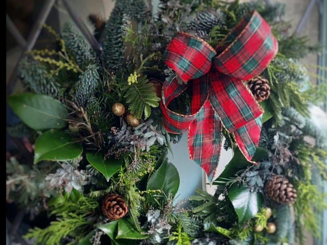 A Christmas wreath with a tartan bow, wreath making workshop at Court Farm Lakes