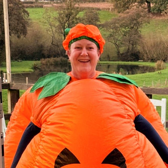 A swimmer in an inflatable pumpkin costume by the lake, Halloween glo swim at Court Farm Lakes