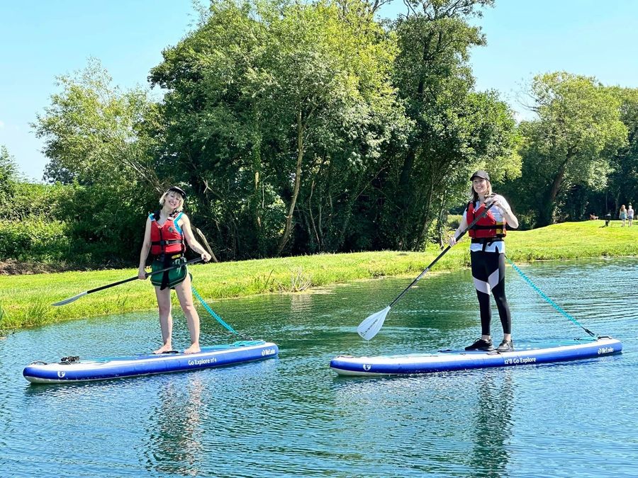 Two paddleboarders on the lake in summer at Court Farm Lakes