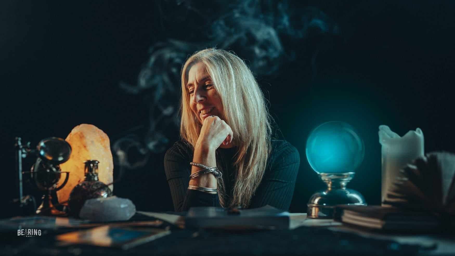 a person sitting at a table with a crystal ball & Smoke
